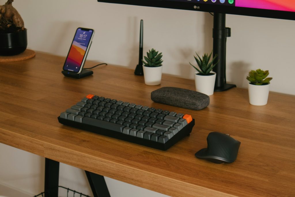 充電器、キーボード、マウスを含むデスクの画像